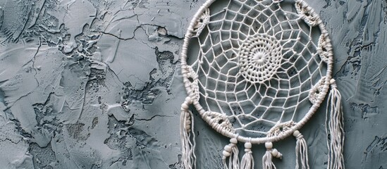 Poster - Close up of a white crochet dream catcher against a textured gray surface resembling concrete with space for text in the image. with copy space image. Place for adding text or design