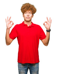 Wall Mural - Young handsome man with afro hair wearing red t-shirt relax and smiling with eyes closed doing meditation gesture with fingers. Yoga concept.