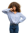 © Krakenimages.com - African american woman wearing a stripes shirt with angry face, negative sign showing dislike with thumbs down, rejection concept