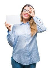 Canvas Print - Young beautiful business woman holding blank card over isolated background with happy face smiling doing ok sign with hand on eye looking through fingers