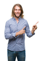 Canvas Print - Young handsome man with long hair over isolated background smiling and looking at the camera pointing with two hands and fingers to the side.