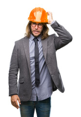 Canvas Print - Young handsome architec man with long hair wearing safety helmet over isolated background confuse and wonder about question. Uncertain with doubt, thinking with hand on head. Pensive concept.