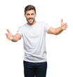 © Krakenimages.com - Young handsome man over isolated background looking at the camera smiling with open arms for hug. Cheerful expression embracing happiness.
