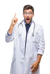 Sticker - Young handsome doctor man over isolated background pointing finger up with successful idea. Exited and happy. Number one.