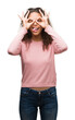 © Krakenimages.com - Beautiful young hispanic woman wearing sunglasses doing ok gesture like binoculars sticking tongue out, eyes looking through fingers. Crazy expression.