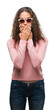 © Krakenimages.com - Beautiful young hispanic woman wearing sunglasses shocked covering mouth with hands for mistake. Secret concept.