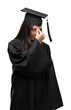 © Krakenimages.com - Young hispanic woman wearing graduated cap and uniform tired rubbing nose and eyes feeling fatigue and headache. Stress and frustration concept.
