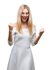 Poster - Young beautiful blonde woman wearing glasses over isolated background very happy and excited doing winner gesture with arms raised, smiling and screaming for success. Celebration concept.