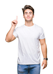 Sticker - Young handsome man wearing white t-shirt over isolated background showing and pointing up with finger number one while smiling confident and happy.