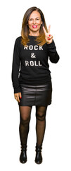 Canvas Print - Beautiful middle age woman wearing rock and roll sweater showing and pointing up with fingers number two while smiling confident and happy.