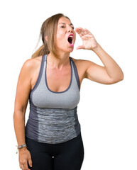 Poster - Beautiful middle age woman wearing sport clothes over isolated background shouting and screaming loud to side with hand on mouth. Communication concept.