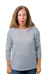 Wall Mural - Beautiful middle age woman wearing stripes sweater over isolated background In shock face, looking skeptical and sarcastic, surprised with open mouth