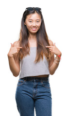 Canvas Print - Young asian woman wearing sunglasses over isolated background looking confident with smile on face, pointing oneself with fingers proud and happy.