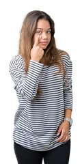 Poster - Young beautiful brunette woman wearing stripes sweater over isolated background Pointing to the eye watching you gesture, suspicious expression