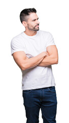 Canvas Print - Young man wearing casual white t-shirt over isolated background smiling looking to the side with arms crossed convinced and confident