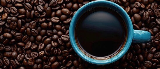 Aufkleber - Top down view of a black coffee filled blue cup set against a background of freshly roasted coffee beans creating a copy space image