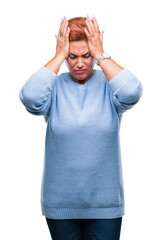 Wall Mural - Atrractive senior caucasian redhead woman over isolated background suffering from headache desperate and stressed because pain and migraine. Hands on head.