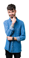 Canvas Print - Young handsome man over isolated background looking confident at the camera with smile with crossed arms and hand raised on chin. Thinking positive.