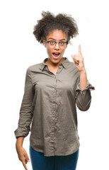 Sticker - Young afro american woman wearing glasses over isolated background pointing finger up with successful idea. Exited and happy. Number one.