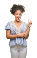 Poster - Young afro american woman over isolated background smiling with happy face winking at the camera doing victory sign. Number two.