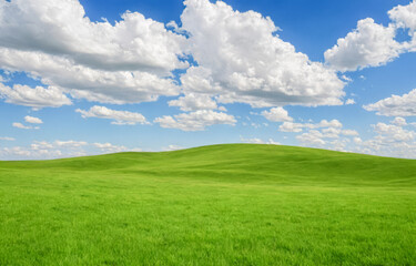 green hill landscape under blue sky with white clouds, serene nature background, vibrant grass field