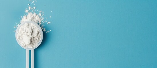 Aufkleber - White powder in a plastic spoon arranged on a blue background in a composition ideal for adding text suitable for display with copy space image