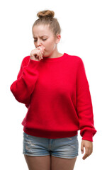 Wall Mural - Young blonde woman wearing bun and red sweater feeling unwell and coughing as symptom for cold or bronchitis. Healthcare concept.