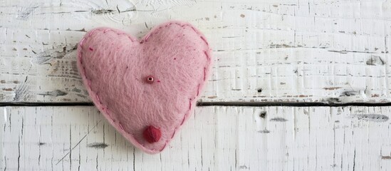 Poster - A pink felt heart handmade for Valentine s Day on a white shabby wooden backdrop with ample copy space image