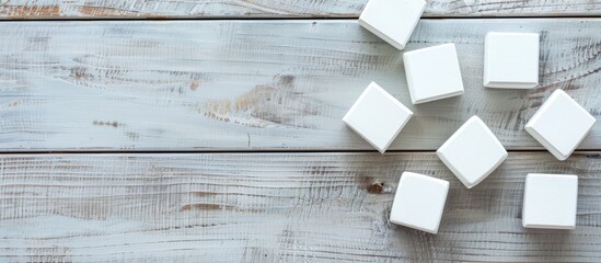 Poster - Flat lay of blank cubes on a light grey wooden table with a free area for text Includes a copy space image