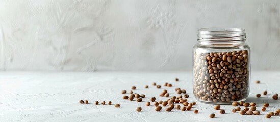 Leinwandbilder - Glass jar filled with raw beans on a white table background providing ample copy space for text