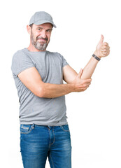 Canvas Print - Handsome middle age hoary senior man wearing sport cap over isolated background Looking proud, smiling doing thumbs up gesture to the side