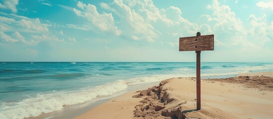 Poster - Scenic beach sign against a backdrop of the sea perfect for travel themed copy space image
