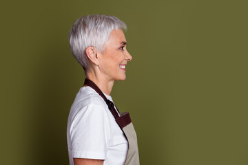 Sticker - Side photo of adorable happy woman wear apron serving beverages smiling empty space isolated khaki color background