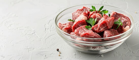 Poster - Glass bowl with fresh raw meat on a white backdrop perfect for copy space image