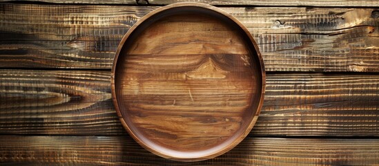Leinwandbilder - Top view of a round wooden plate or tray set against a rustic wooden backdrop with sufficient vacant space for text or images forming a copy space image