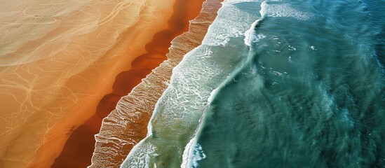 Poster - An aerial shot captures the beach split by the surf creating a diagonal division in the copy space image