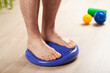 © Olga Miltsova - man doing flatfoot correction gymnastic exercise balancing on massage cushion at home