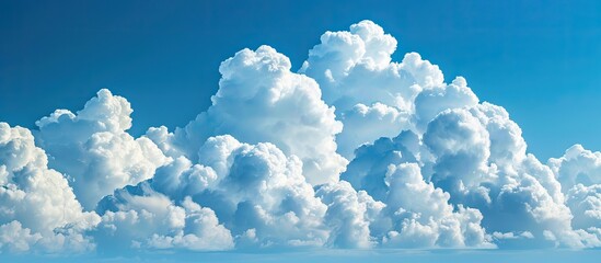 Wall Mural - puffy white clouds floating in a clear blue sky with ample copy space image