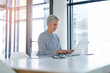 © peopleimages.com - Woman, research and table with laptop in office for investment, report and reading finance news. Mature financial advisor, notes and typing with tech for foreign exchange, trading or update to client