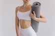 © anatoliycherkas - Сropped close-up photo of young woman holding yoga mat isolated on white background, panoramic banner, Sport, fitness, meditation, yoga balance, mindfulness, workout, healthy lifestyle concept