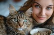 © DKPhoto - A young woman and her cat are seen up close, with both their faces side by side, showcasing their gorgeous blue eyes and creating a charming moment filled with affection.