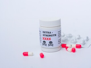 Medication capsules next to white bottle on a white background with copy space