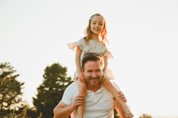 Wall Mural - happy child girl and father are playing in field.