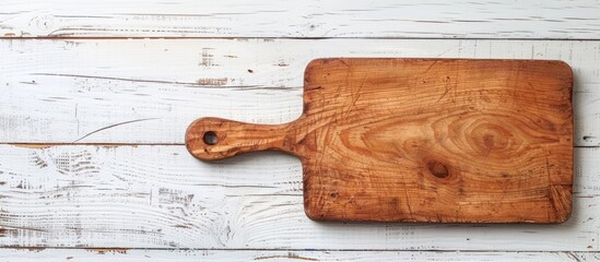 Poster - Top view of wooden cutting board on a textured white wood table with copy space image