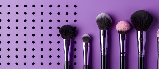 Wall Mural - High quality makeup brushes held against a purple backdrop with visible holes Suitable for adding text alongside the image. Copy space image. Place for adding text and design