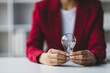 © Wasan - Businesswoman hand holding light bulb and idea.