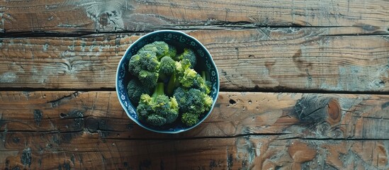 Poster - Fresh raw broccoli in a bowl placed on a wooden table captured in a close up shot with available space for adding text in the image. Copy space image. Place for adding text and design