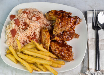 Wall Mural - chicken wings  with  rice and tomatoes served wth fries