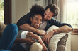 © aLListar/peopleimages.com - Home, happy and couple with hug on sofa for weekend romance, partnership and bonding together. Man, love and woman with affection in living room on couch for connection, support and trust in marriage