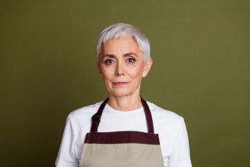 Wall Mural - Photo of charming positive woman wear apron serving coffee empty space isolated khaki color background